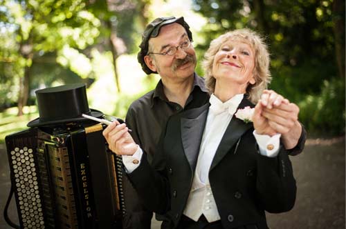 Hellmann und Denker mit Akkordeon und Zyliner im Park