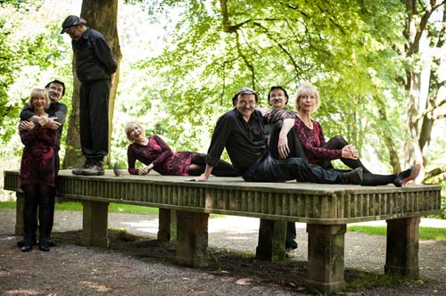 Hellmann und Denker stehend und sitzend auf einer Steinplatte im Park